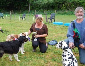 Dog and handlers with their agility show prizes